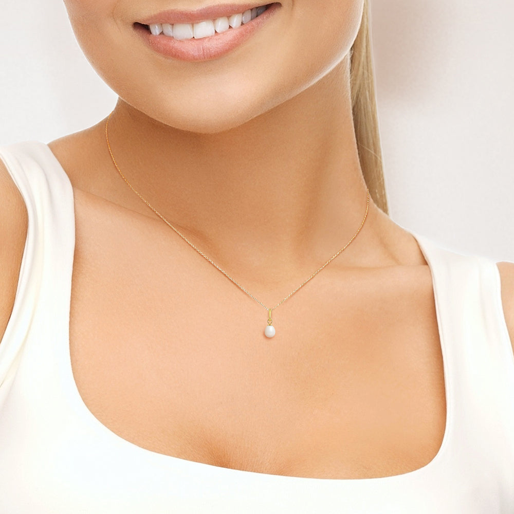 Femme portant un pendentif perle blanche naturel sur chaîne or jaune  –  KENVIA

