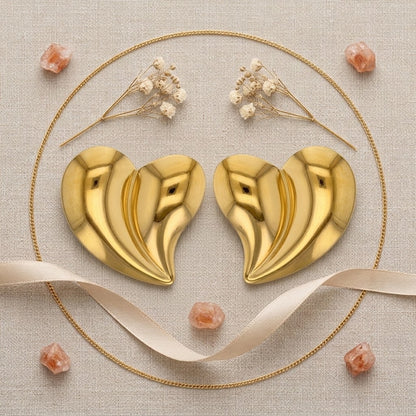 Boucles d’oreilles cœur spirale en acier inoxydable 316L finition dorées présentées dans une composition décorative - KENVIA