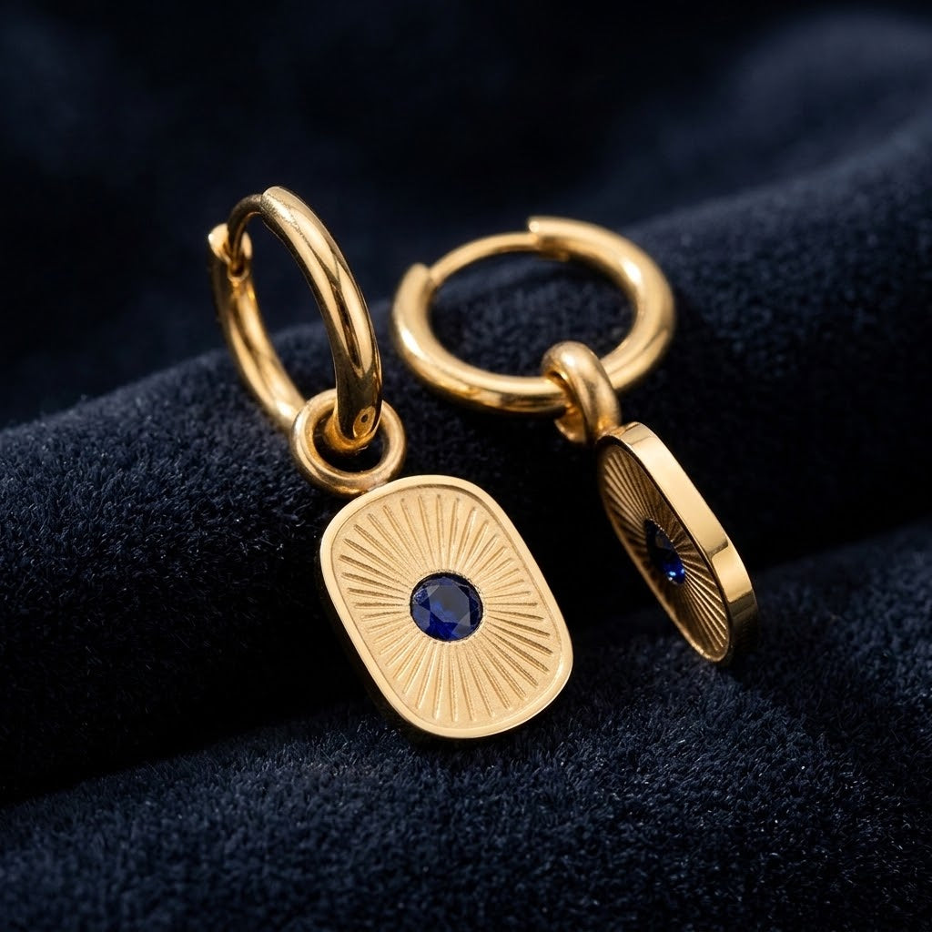  Paire de boucles d’oreilles dorées et résine bleue présentée sur un velours bleu - KENVIA