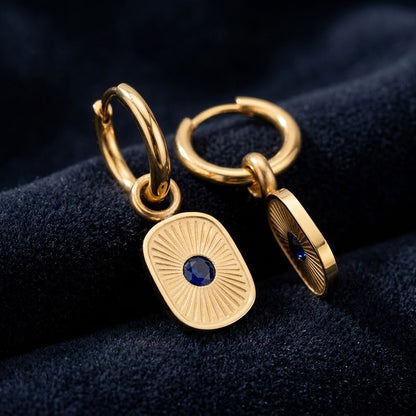  Paire de boucles d’oreilles dorées et résine bleue présentée sur un velours bleu - KENVIA