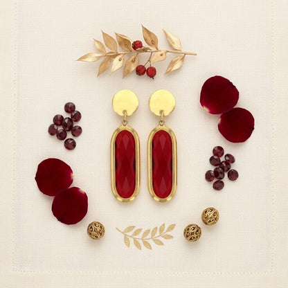 Paire de boucles d’oreilles ovales rouges présentée avec des éléments décoratifs - KENVIA