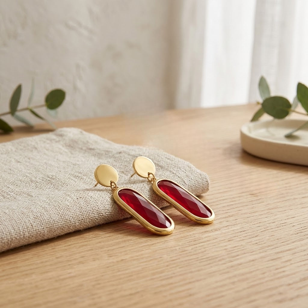 Boucles d’oreilles ovales rouges présentées sur une surface claire - KENVIA