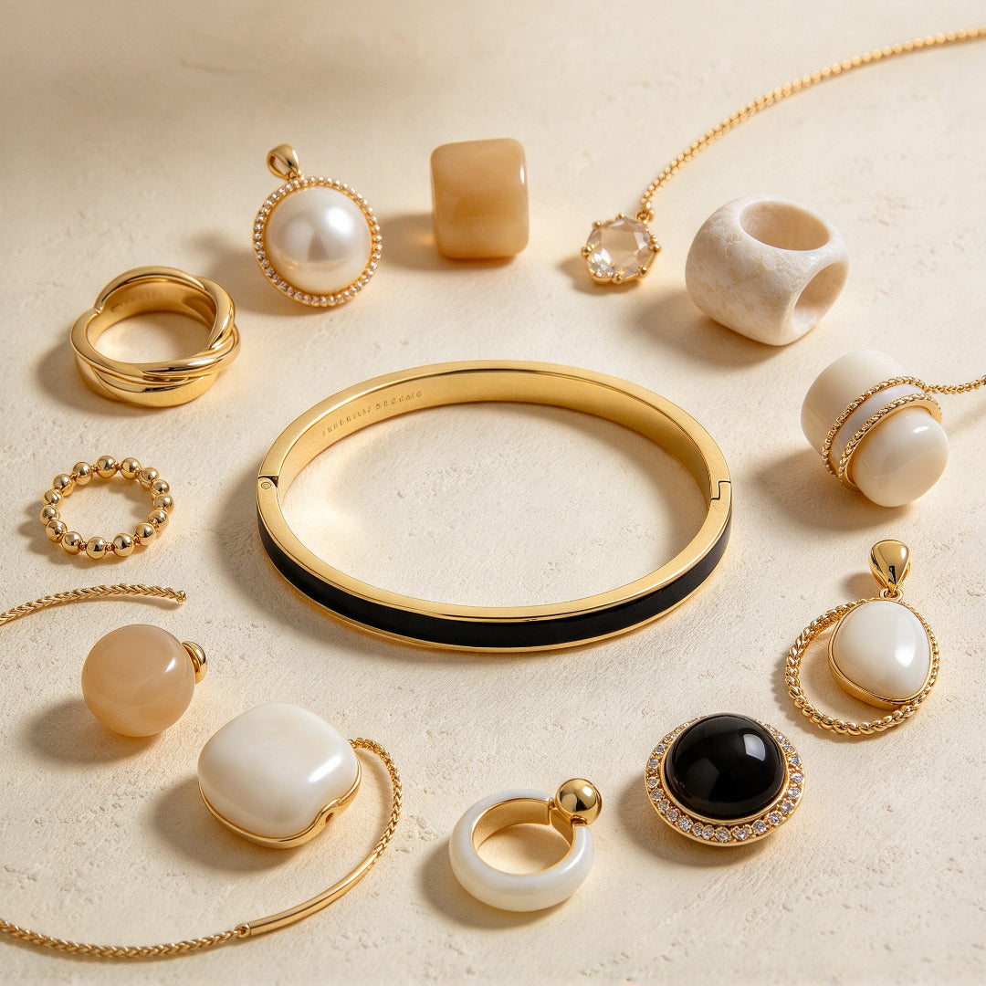 Bracelet jonc fin à finition dorée et émail noir présenté dans une composition de bijoux - KENVIA