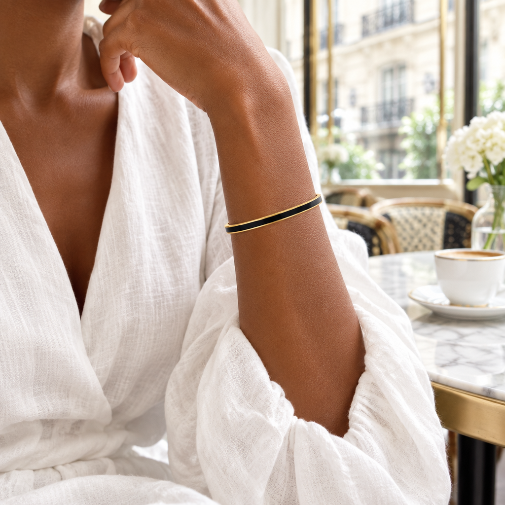 Bracelet jonc fin à finition dorée et émail noir porté au bras - KENVIA