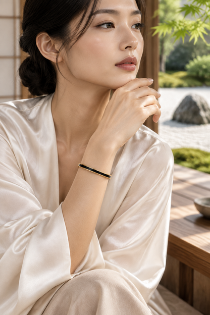 Femme portant le bracelet jonc fin  en acier inoxydable 316L à finition dorée et émail noir - KENVA