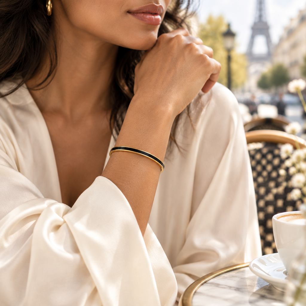 bracelet jonc à finition dorée et émail noir porté au poignet - KENVIA