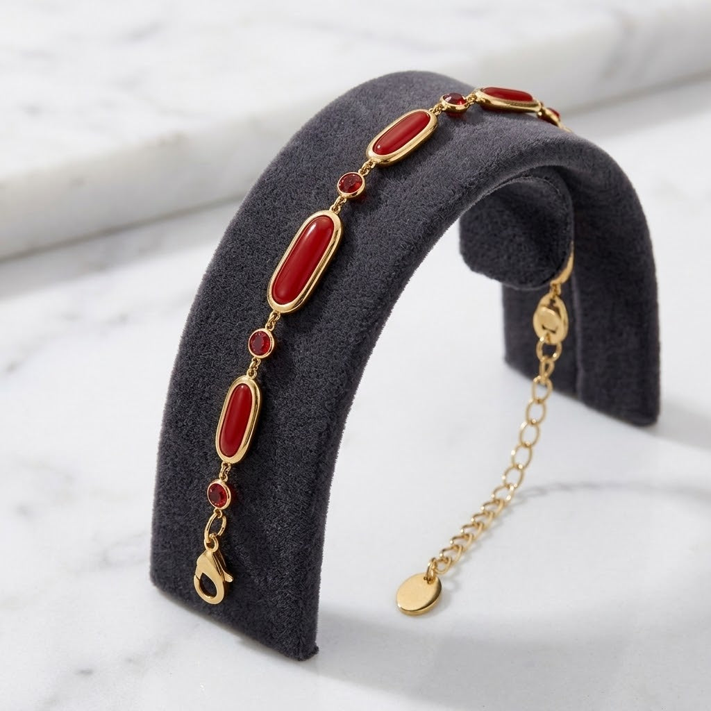 Bracelet en verre rouge et acier inoxydable 316L finition dorée présenté sur un support anthracite - KENVIA