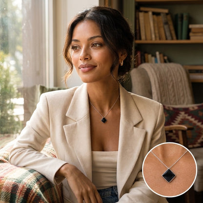 Portrait d’une femme en veste claire portant le collier à pendentif losange noir - KENVIA