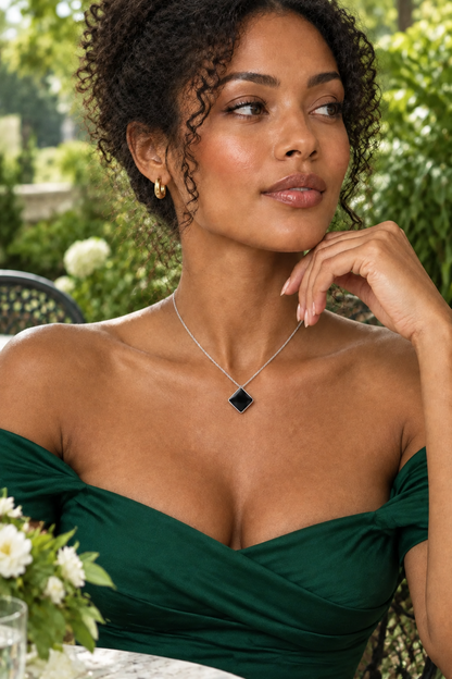 Femme en tenue verte portant le collier à pendentif losange noir - KENVIA