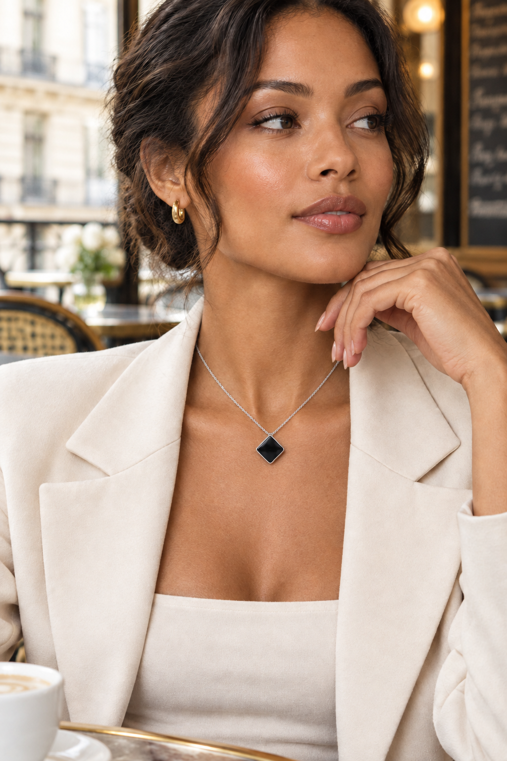 Femme portant le collier à pendentif losange noir avec une veste claire, vue de profil - KENVIA