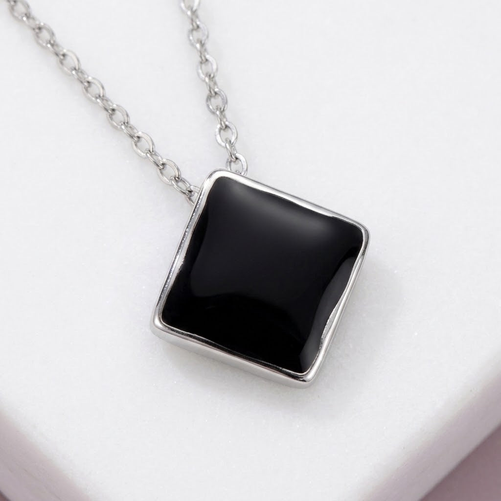 Gros plan sur le pendentif losange en résine noire et sa chaîne en acier inoxydable 316L - KENVIA